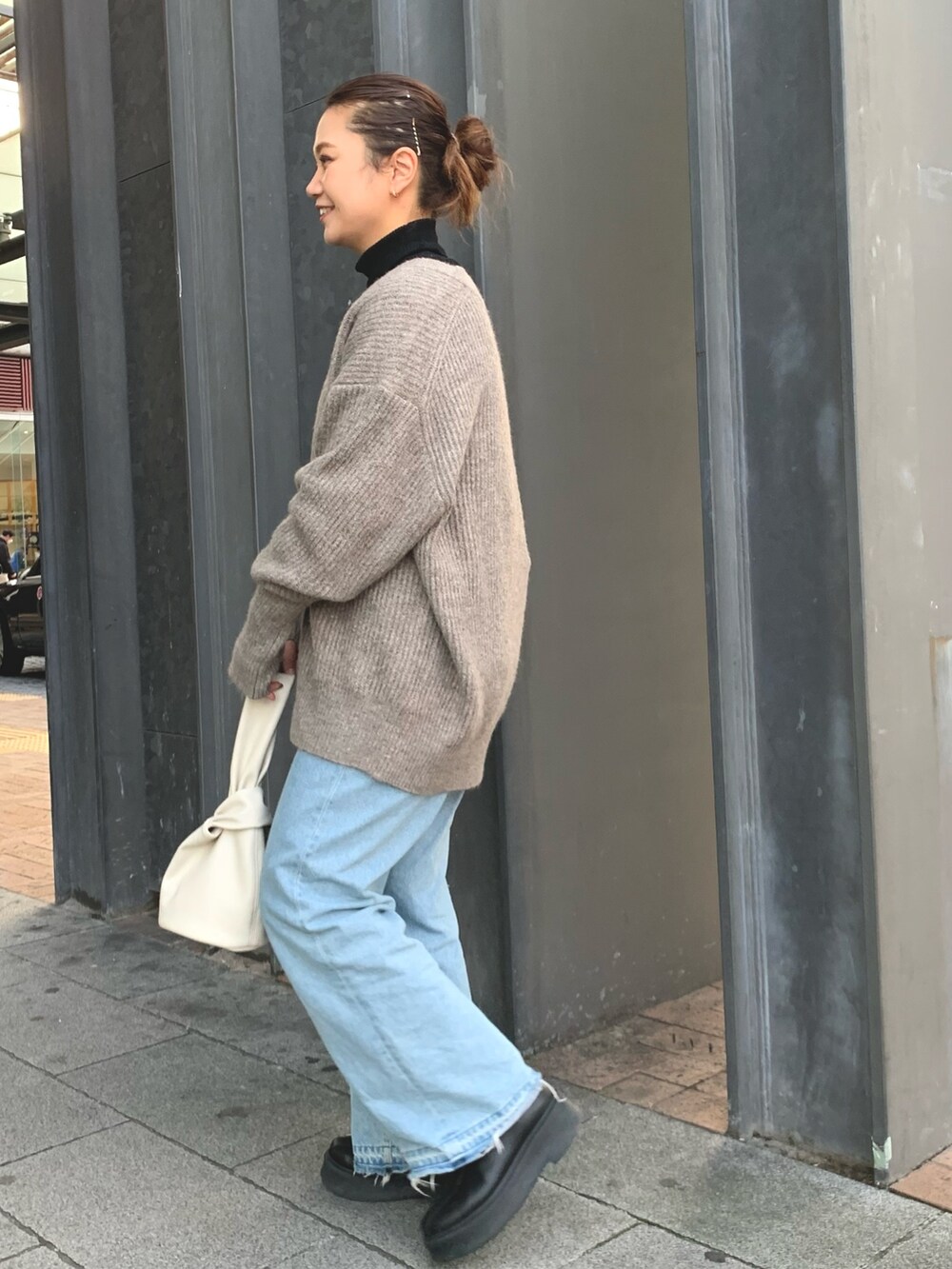 ホワイト系のハンドバッグ、グレー系のカーディガン/ボレロ、ブラック系のニット/セーターを着用したレディースの冬コーディネートの2枚目の写真