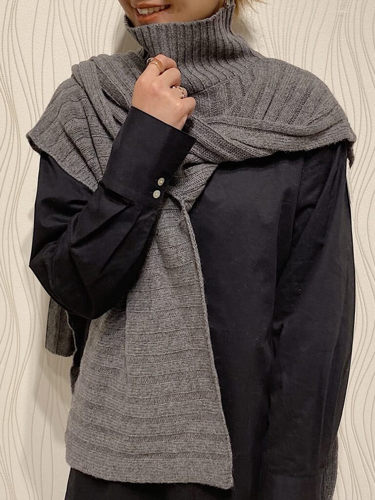 ホワイト系のハンドバッグ、ブラック系のワンピース、グレー系のニット/セーターを着用したレディースの秋コーディネートの2枚目の写真