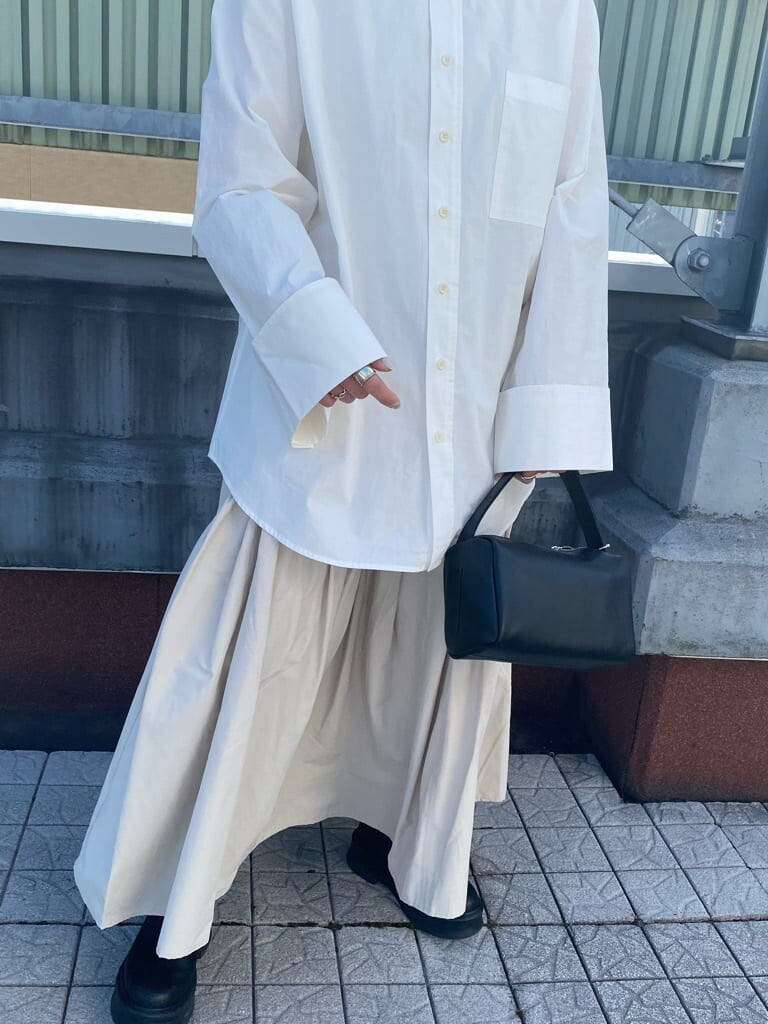 ブラック系のハンドバッグ、ホワイト系のシャツ/ブラウス、ホワイト系のスカートを着用したレディースの冬コーディネートの3枚目の写真