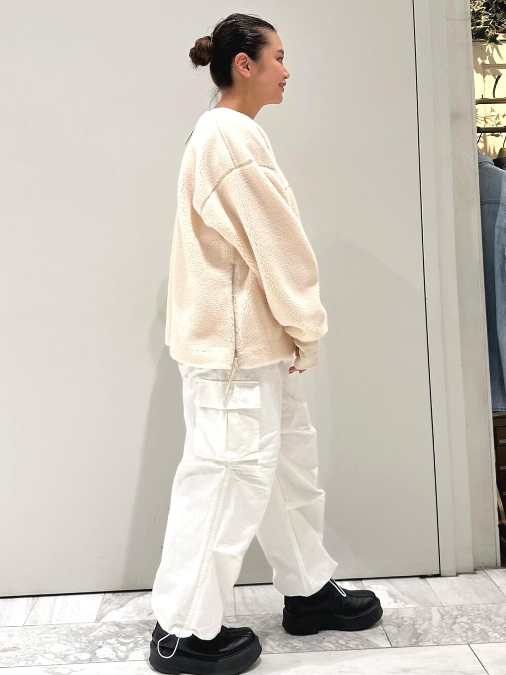 ホワイト系のカーゴパンツ、ブラック系のブーツ、ホワイト系のTシャツ/カットソーを着用したレディースの秋コーディネートの2枚目の写真