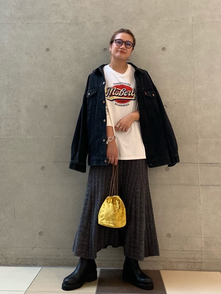 ブラック系のデニムジャケット、グレー系のスカート、イエロー系のハンドバッグを着用したレディースの秋コーディネートの2枚目の写真