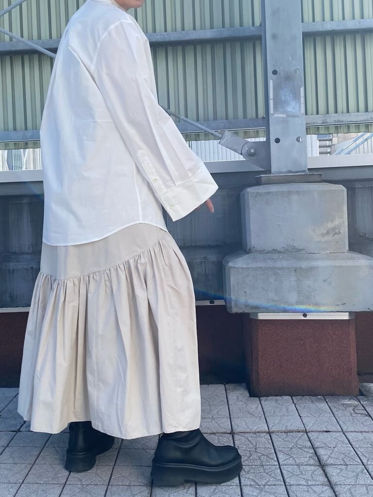 ブラック系のハンドバッグ、ホワイト系のシャツ/ブラウス、ホワイト系のスカートを着用したレディースの冬コーディネートの2枚目の写真