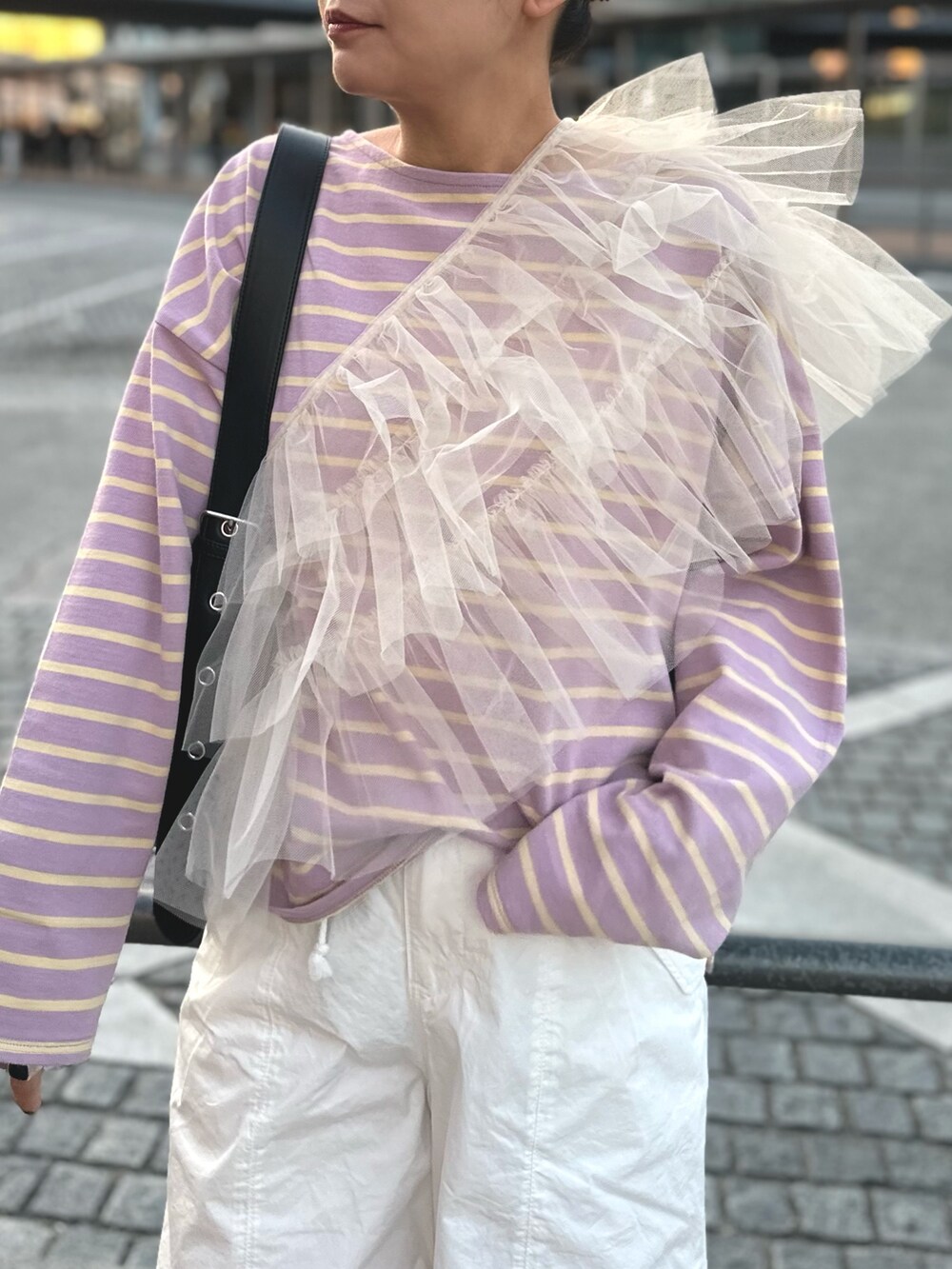 ベージュ系のベスト、ホワイト系のその他パンツ、ブラック系のショルダーバッグを着用したレディースの冬コーディネートの4枚目の写真