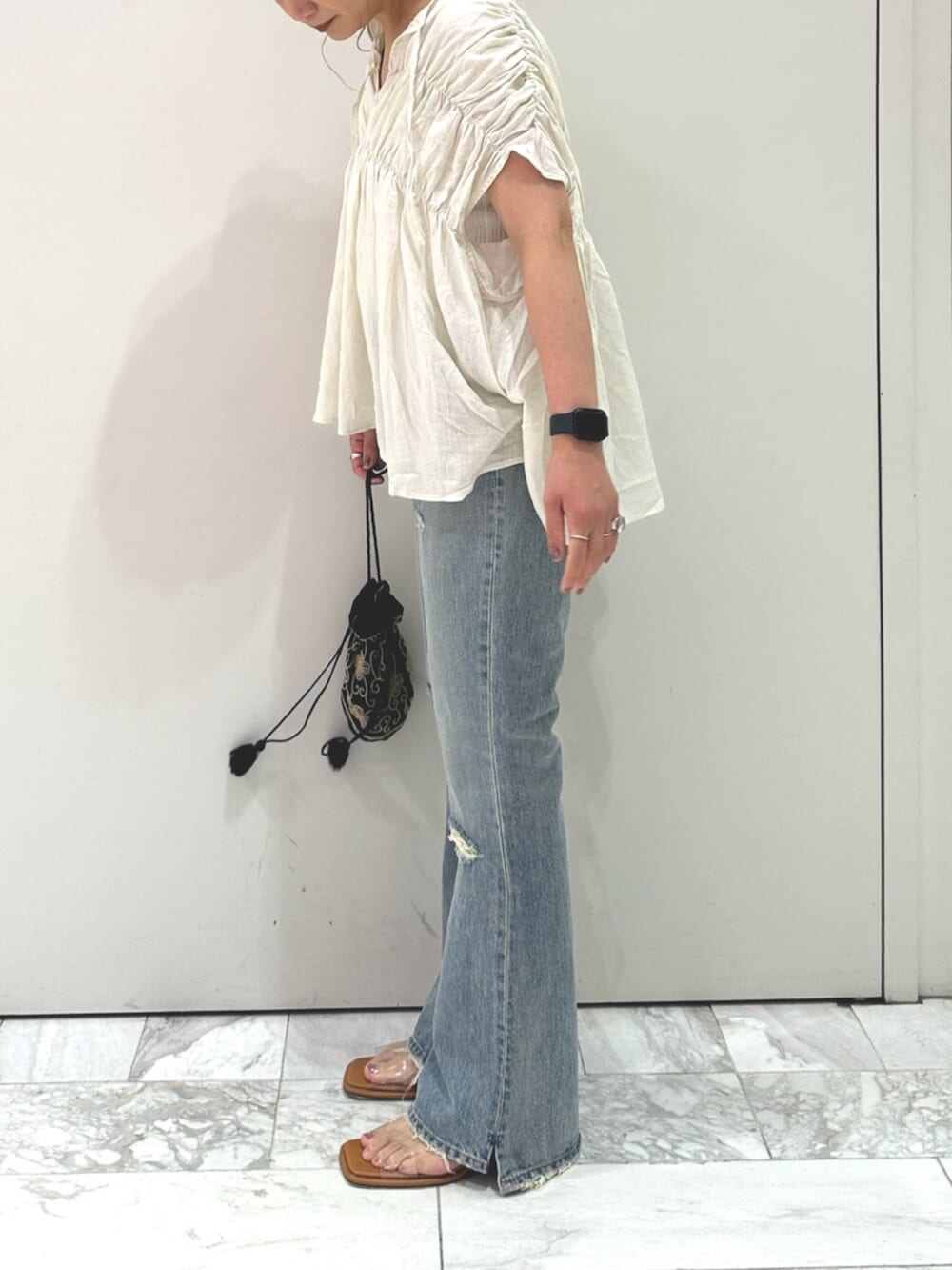 ホワイト系のシャツ/ブラウス、ブルー系のデニムパンツ、その他のサンダルを着用したレディースの夏コーディネートの2枚目の写真