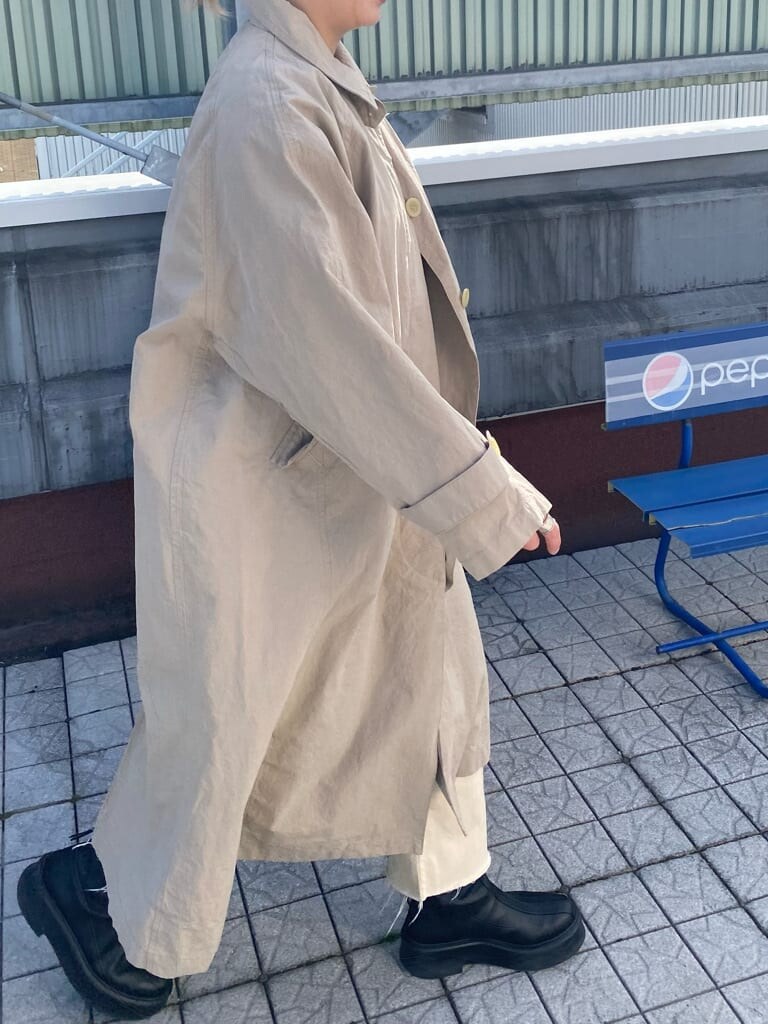 ブルー系のTシャツ/カットソー、ベージュ系のステンカラーコート、ホワイト系のデニムパンツを着用したレディースの冬コーディネートの4枚目の写真