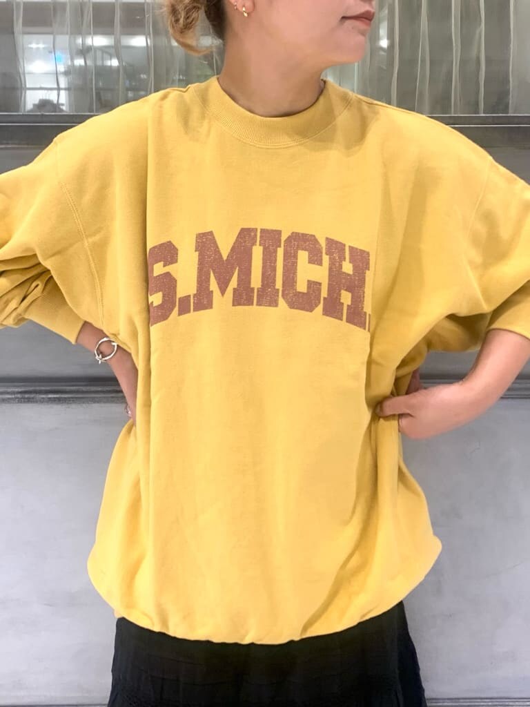 ブラック系のスカート、イエロー系のスウェットを着用したレディースの秋コーディネートの2枚目の写真