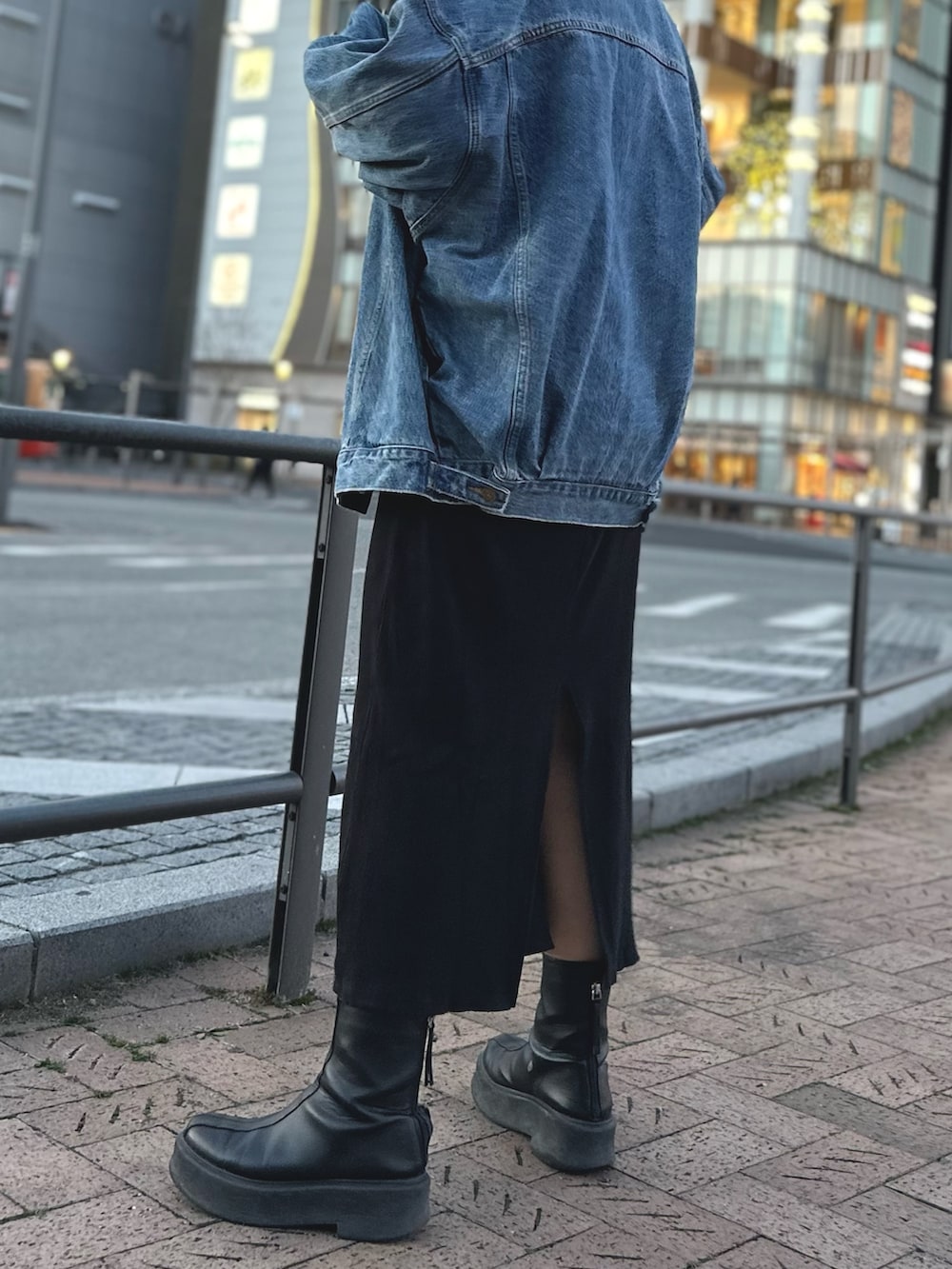 ブラック系のワンピース、ブルー系のデニムジャケット、シルバー系のネックレスを着用したレディースの冬コーディネートの2枚目の写真