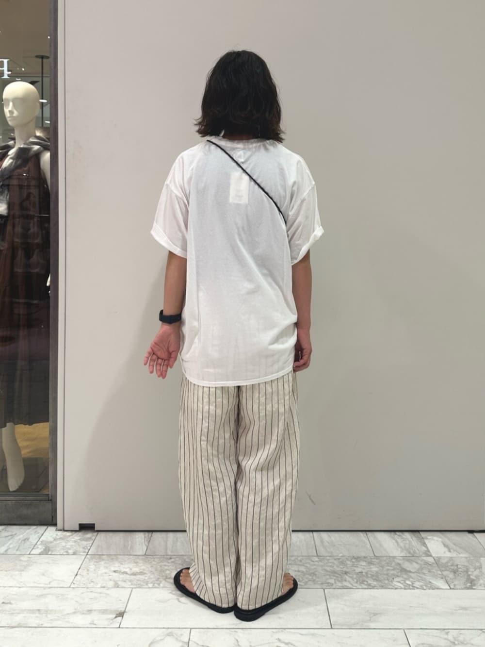 ブラック系のハンドバッグ、ホワイト系のその他パンツ、ホワイト系のTシャツ/カットソーを着用したレディースの夏コーディネートの3枚目の写真