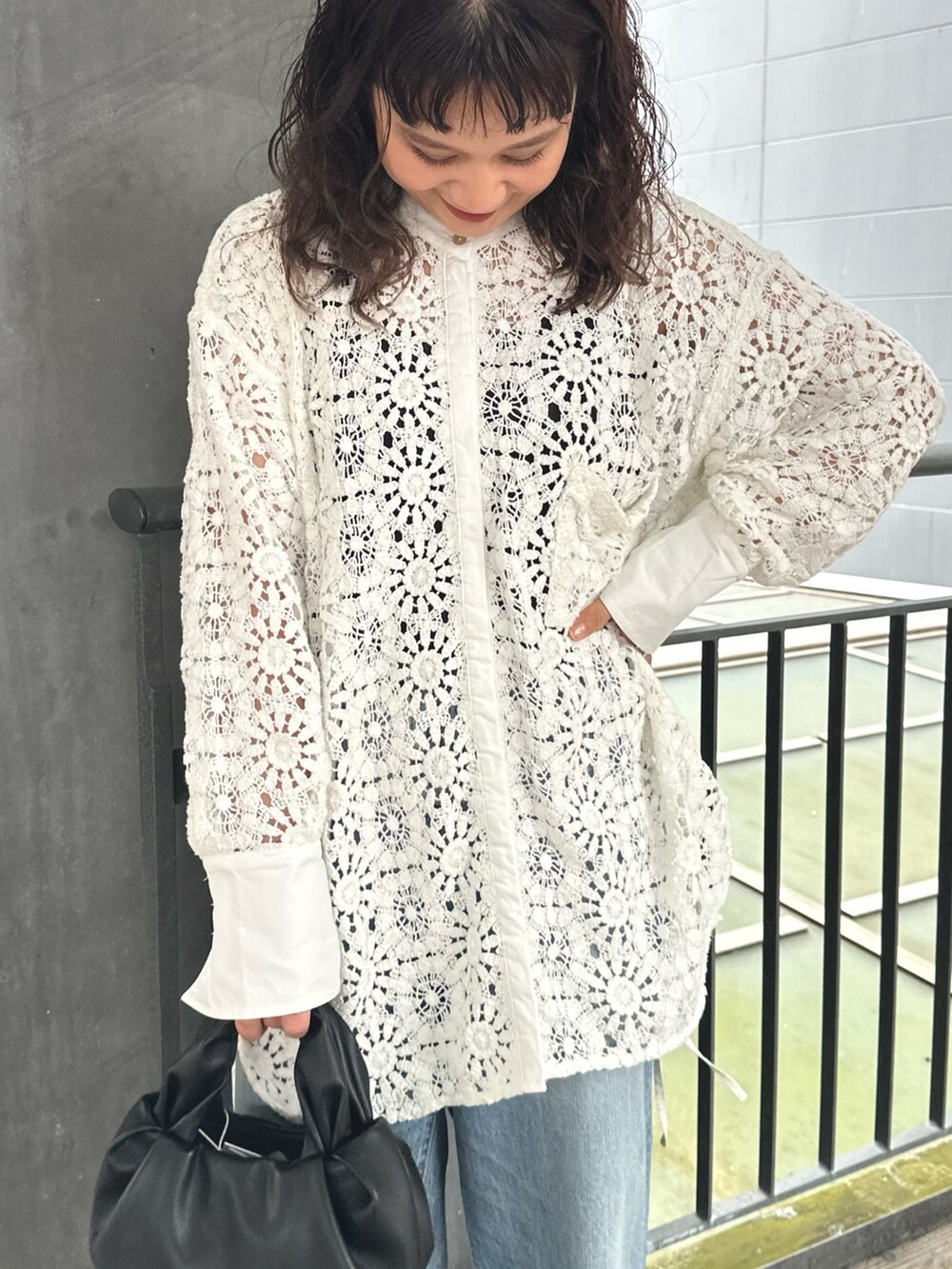 ホワイト系のシャツ/ブラウス、ブラック系のハンドバッグ、ブルー系のデニムパンツを着用したレディースの春コーディネートの4枚目の写真