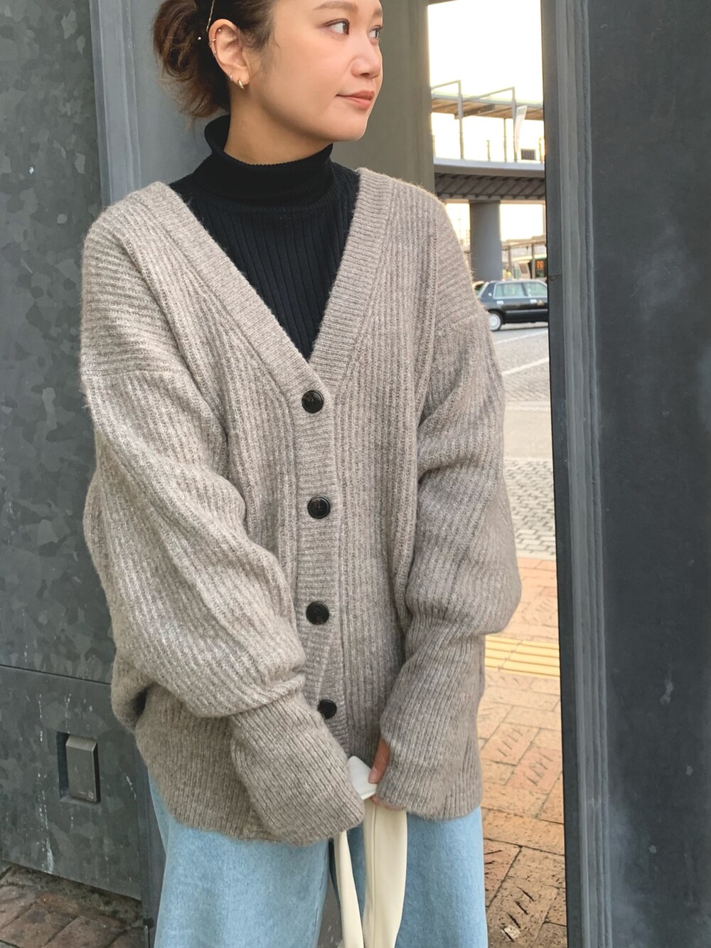 ホワイト系のハンドバッグ、グレー系のカーディガン/ボレロ、ブラック系のニット/セーターを着用したレディースの冬コーディネートの4枚目の写真