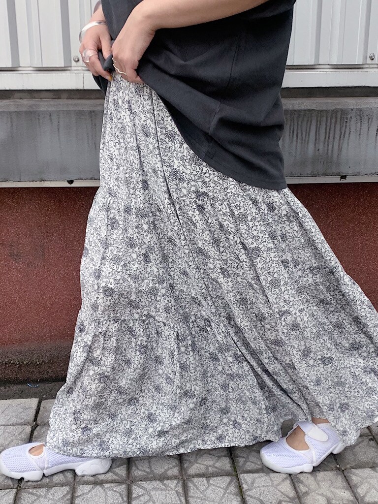 ホワイト系のスカート、ホワイト系のハンドバッグ、グレー系のTシャツ/カットソーを着用したレディースの春コーディネートの2枚目の写真