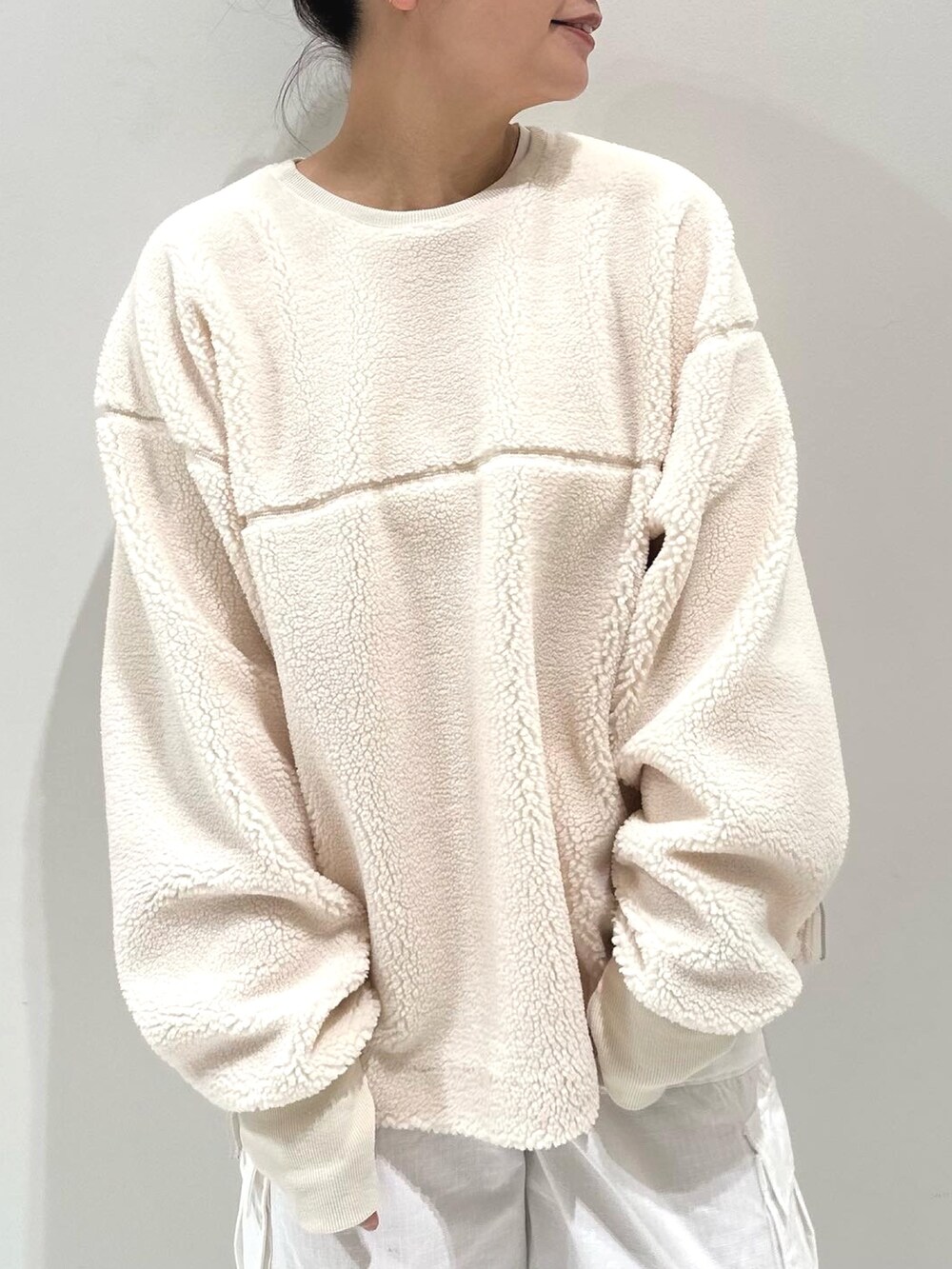 ホワイト系のカーゴパンツ、ブラック系のブーツ、ホワイト系のTシャツ/カットソーを着用したレディースの秋コーディネートの3枚目の写真