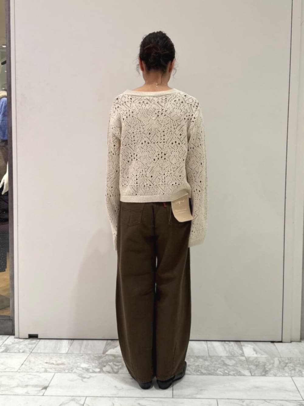ブラック系のその他シューズ、ブラウン系のデニムパンツ、ホワイト系のアンサンブルを着用したレディースの秋コーディネートの3枚目の写真