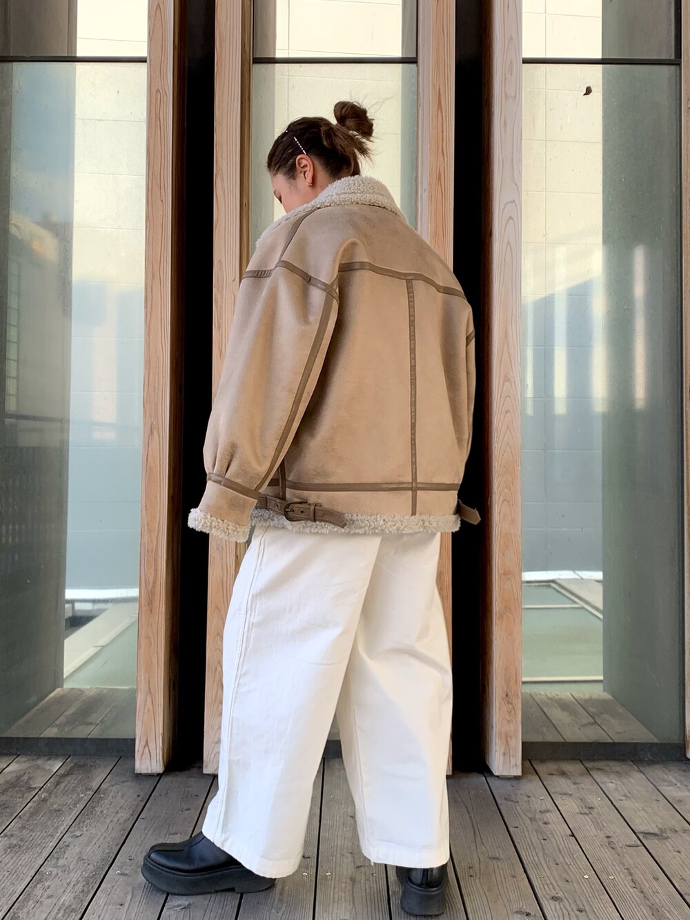 グレー系のスウェット、ホワイト系のその他パンツ、ベージュ系のムートンコートを着用したレディースの冬コーディネートの2枚目の写真