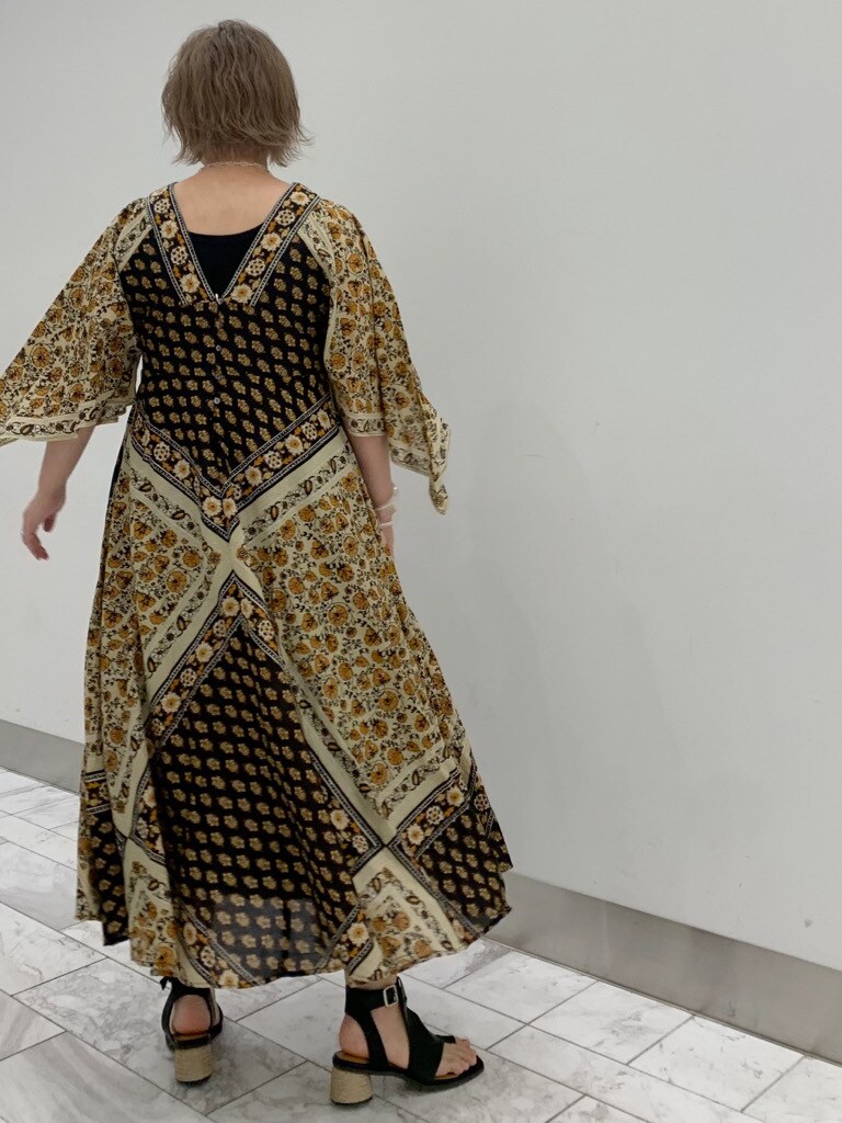 ブラック系のサンダル、イエロー系のワンピースを着用したレディースの夏コーディネートの4枚目の写真