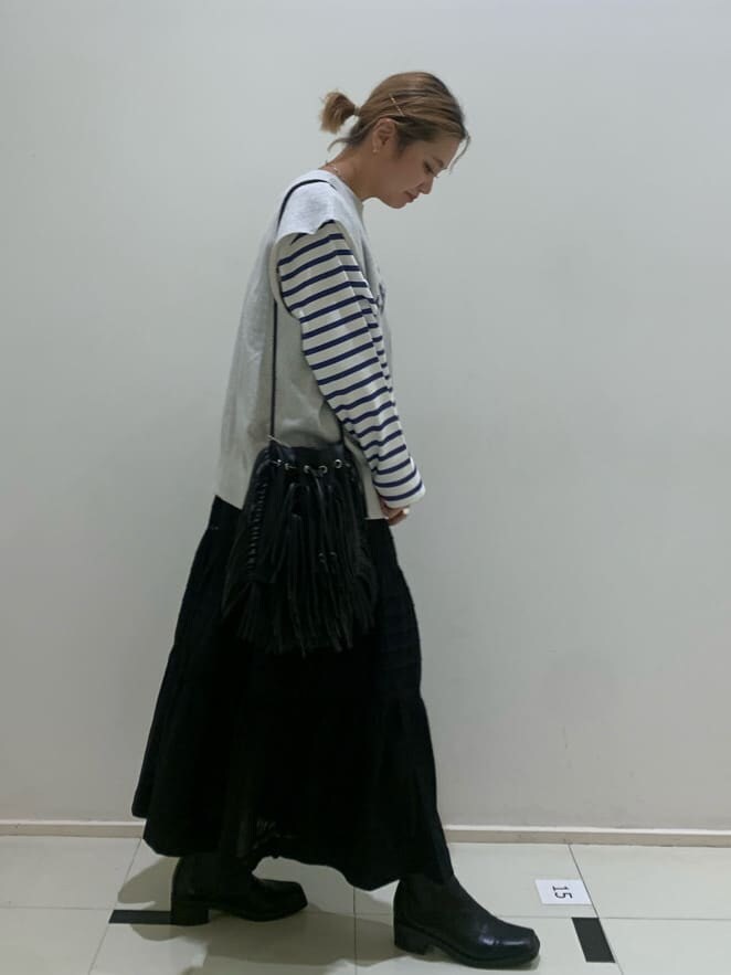 ブラック系のスカート、ブラック系のブーツを着用したレディースの夏コーディネートの2枚目の写真