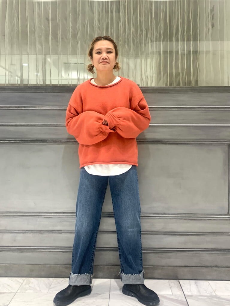 ブルー系のデニムパンツ、ピンク系のニット/セーター、ホワイト系のTシャツ/カットソーを着用したレディースの秋コーディネートの2枚目の写真