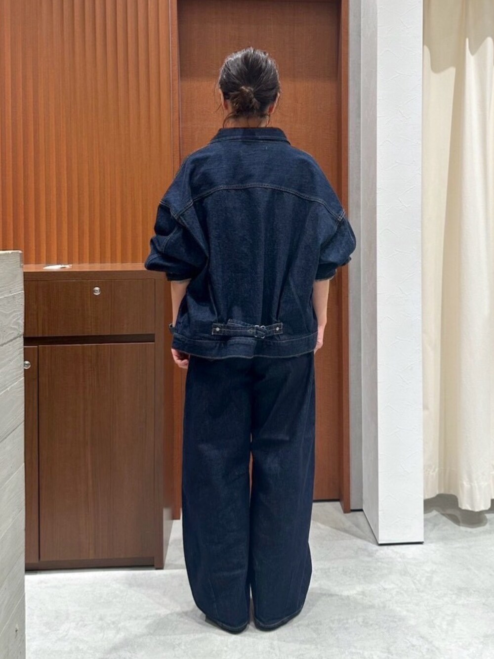 レッド系のニット/セーター、ブラウン系のその他シューズ、ブルー系のデニムパンツを着用したレディースの秋コーディネートの3枚目の写真