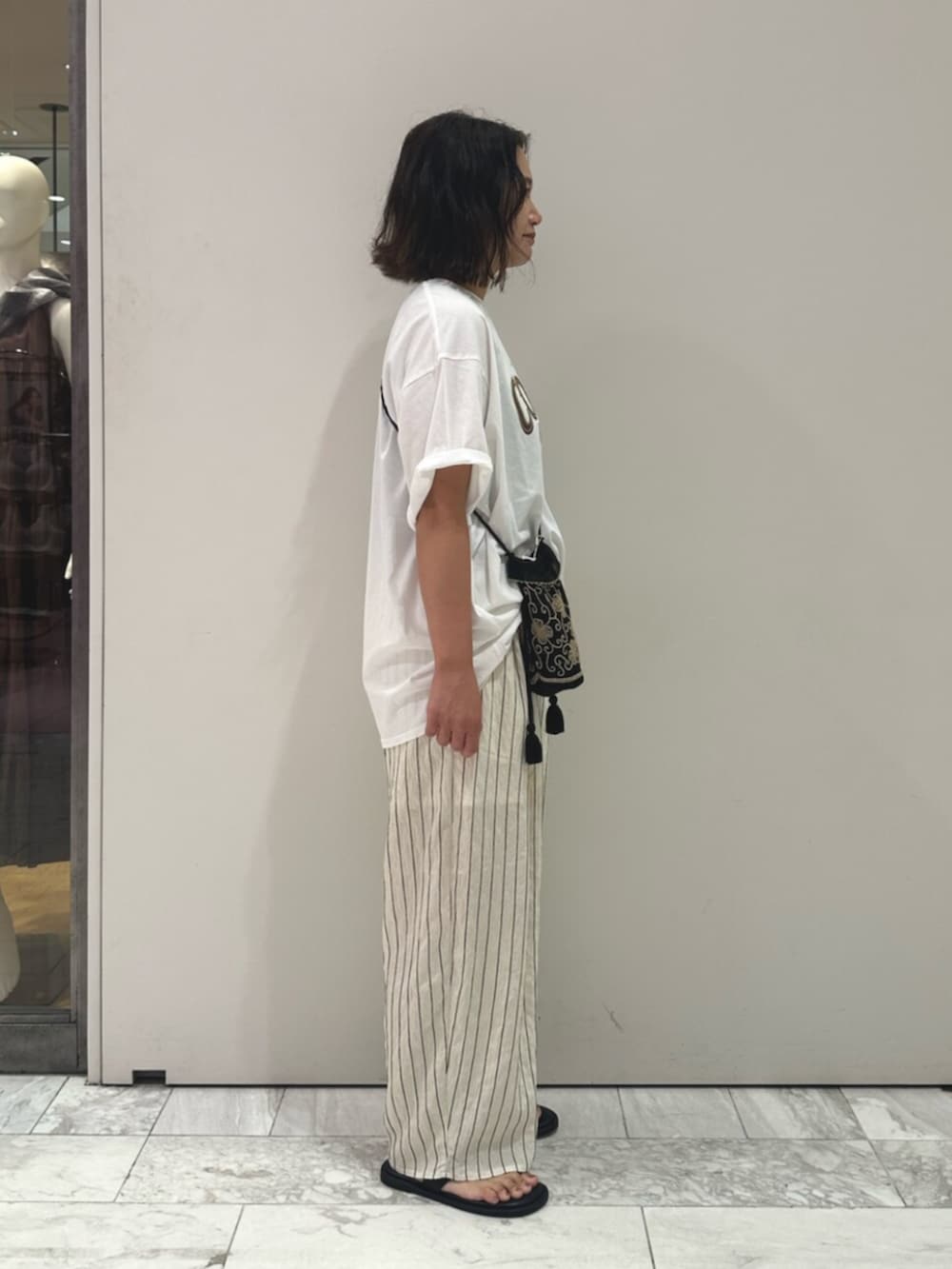 ブラック系のハンドバッグ、ホワイト系のその他パンツ、ホワイト系のTシャツ/カットソーを着用したレディースの夏コーディネートの2枚目の写真