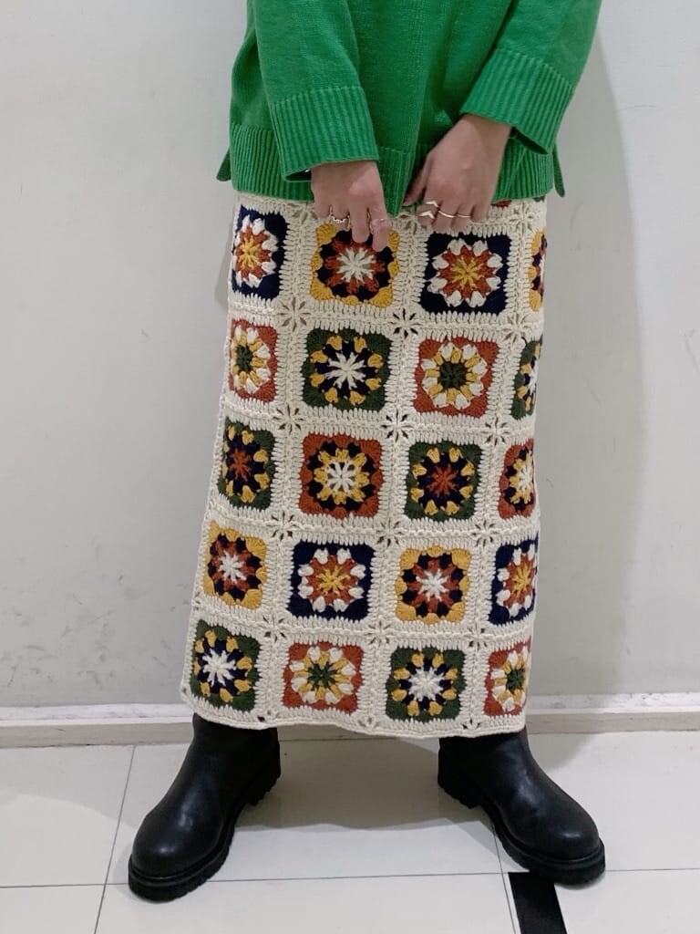 ホワイト系のスカート、ブラック系のブーツ、グリーン系のニット/セーターを着用したレディースの秋コーディネートの3枚目の写真