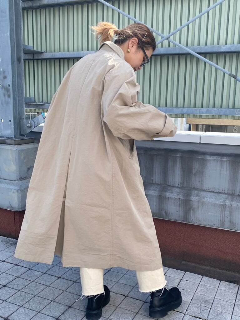 ブルー系のTシャツ/カットソー、ベージュ系のステンカラーコート、ホワイト系のデニムパンツを着用したレディースの冬コーディネートの3枚目の写真