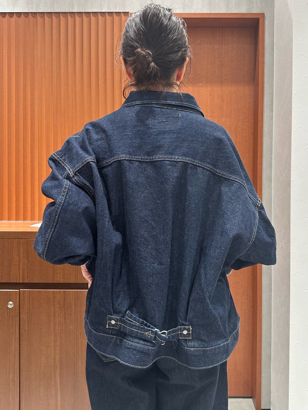 レッド系のニット/セーター、ブラウン系のその他シューズ、ブルー系のデニムパンツを着用したレディースの秋コーディネートの5枚目の写真