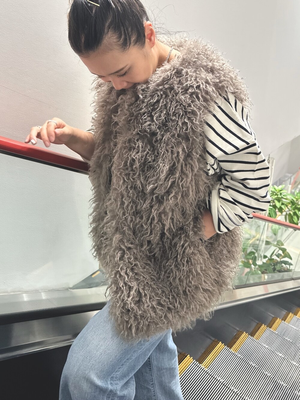 ブルー系のTシャツ/カットソー、ブルー系のデニムパンツ、グレー系のベストを着用したレディースの秋コーディネートの2枚目の写真