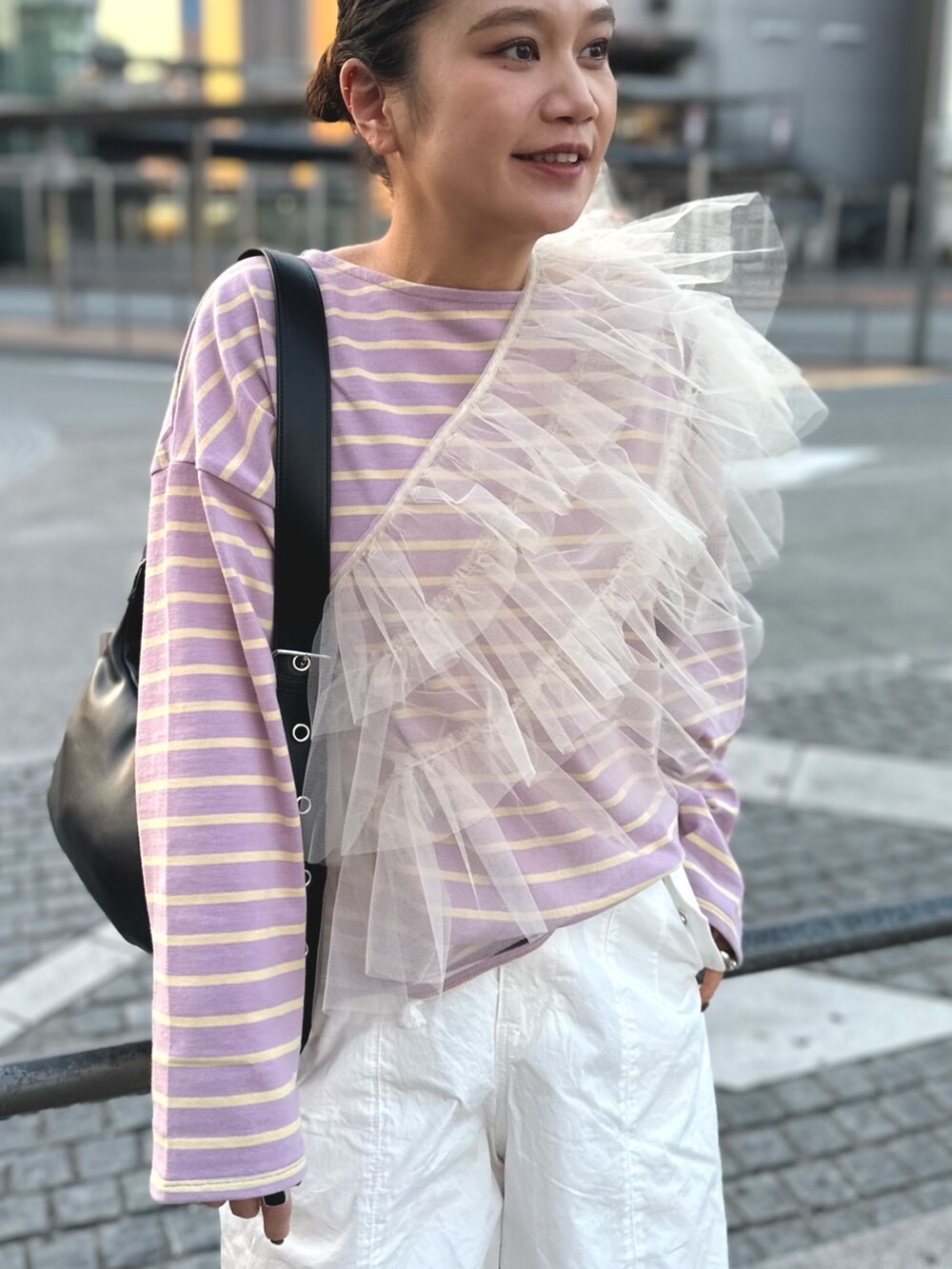 ベージュ系のベスト、ホワイト系のその他パンツ、ブラック系のショルダーバッグを着用したレディースの冬コーディネートの3枚目の写真