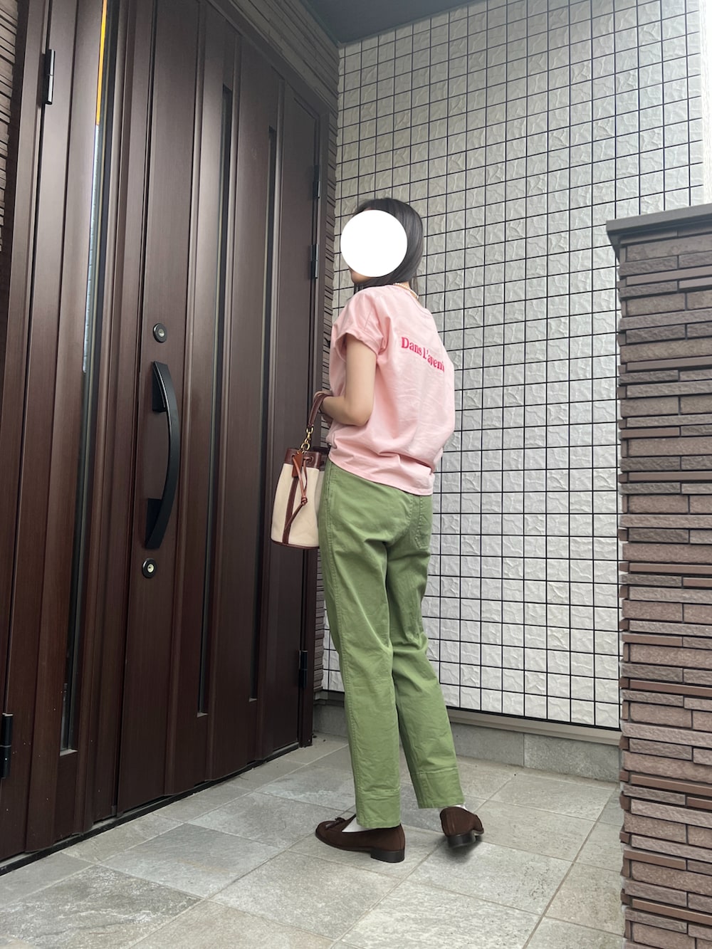 ブラウン系のハンドバッグ、グリーン系のカーゴパンツ、ブラウン系のローファーを着用したレディースの夏コーディネートの2枚目の写真