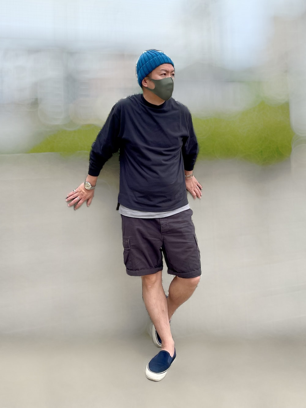 ブラック系のTシャツ/カットソー、ブラック系のカーゴパンツ、ブルー系のスニーカーを着用したメンズの夏コーディネートの2枚目の写真