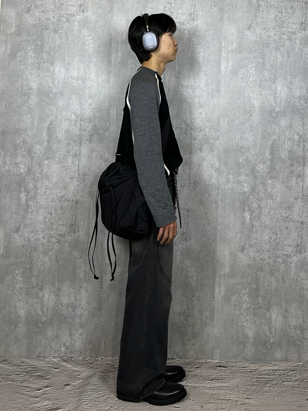 ブラック系のデニムパンツ、ブラック系のブーツ、ブラック系のショルダーバッグを着用したメンズの春コーディネートの4枚目の写真