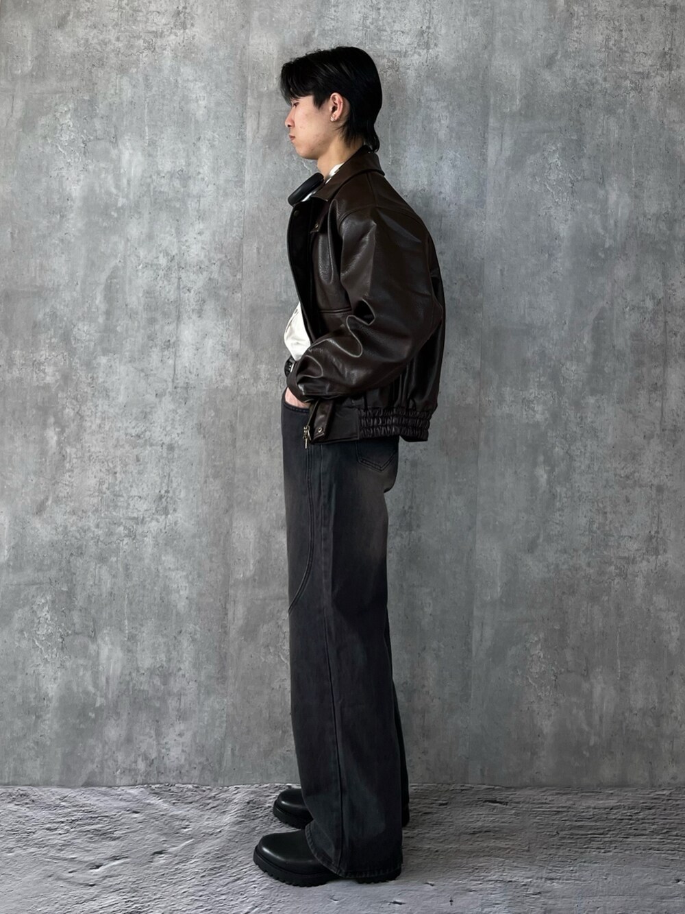 ブラック系のブーツ、ブラック系のデニムパンツ、ブラウン系のブルゾンを着用したメンズの冬コーディネートの3枚目の写真