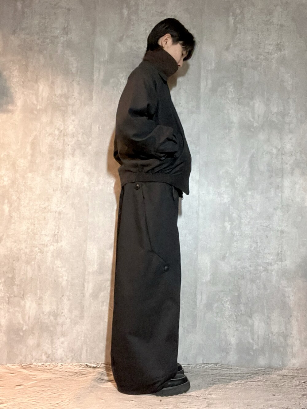 ブラック系のドレスシューズ、ブラウン系のニット/セーター、ブラック系のジャケット/アウターを着用したメンズの冬コーディネートの3枚目の写真