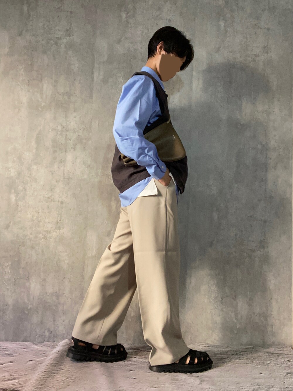 ブラック系のサンダル、ベージュ系のスラックス、ホワイト系のタンクトップを着用したメンズの春コーディネートの4枚目の写真