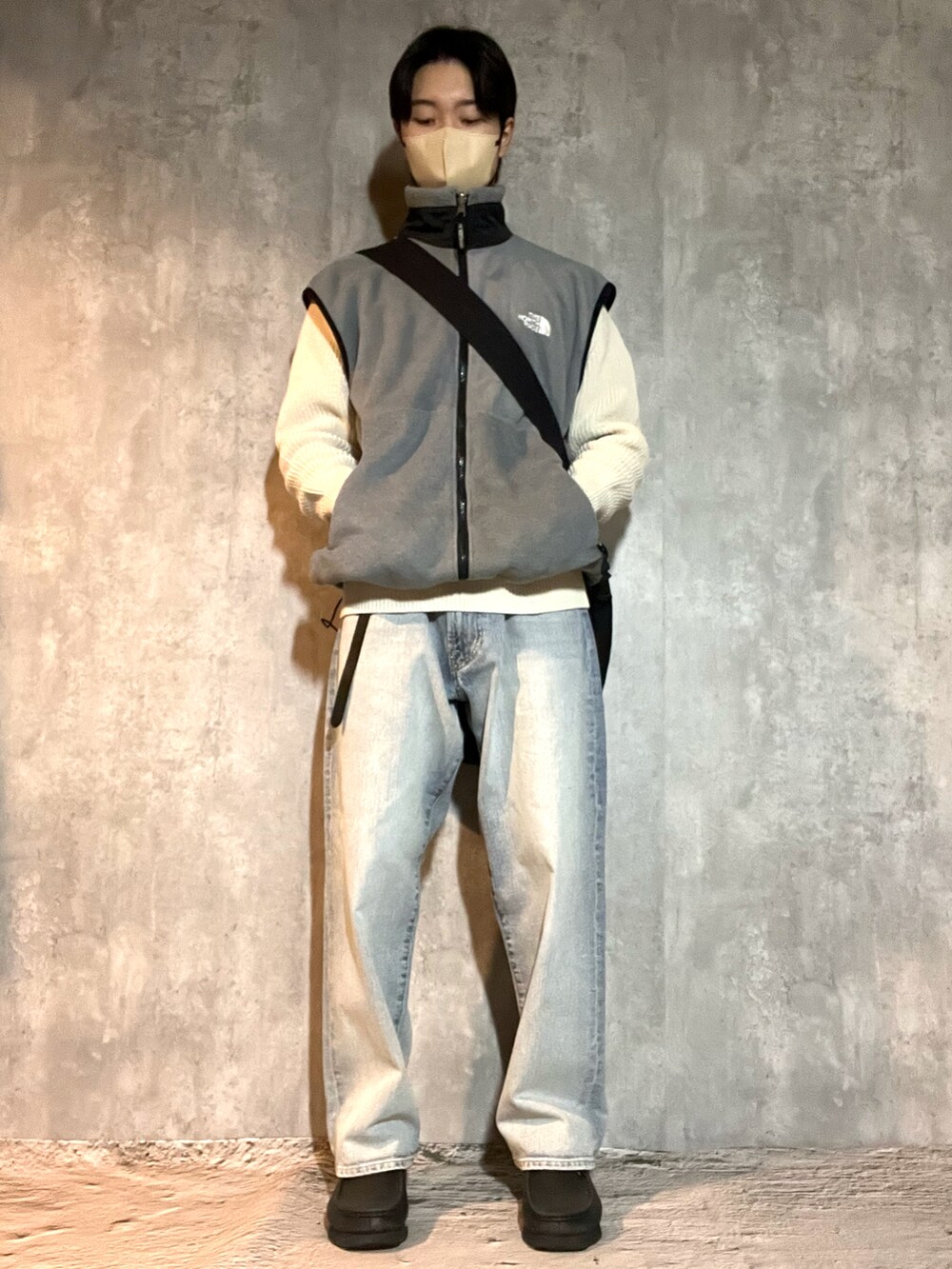 ブラック系のブーツ、ブルー系のデニムパンツ、ホワイト系のニット/セーターを着用したメンズの冬コーディネートの2枚目の写真