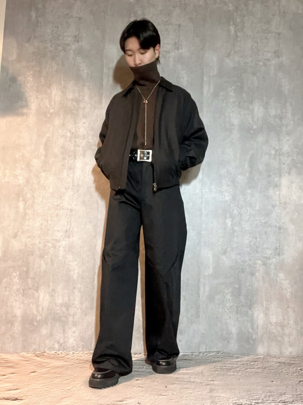 ブラック系のドレスシューズ、ブラウン系のニット/セーター、ブラック系のジャケット/アウターを着用したメンズの冬コーディネートの2枚目の写真