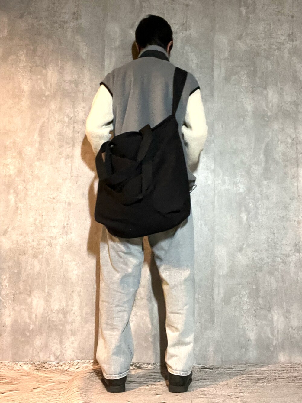 ブラック系のブーツ、ブルー系のデニムパンツ、ホワイト系のニット/セーターを着用したメンズの冬コーディネートの4枚目の写真