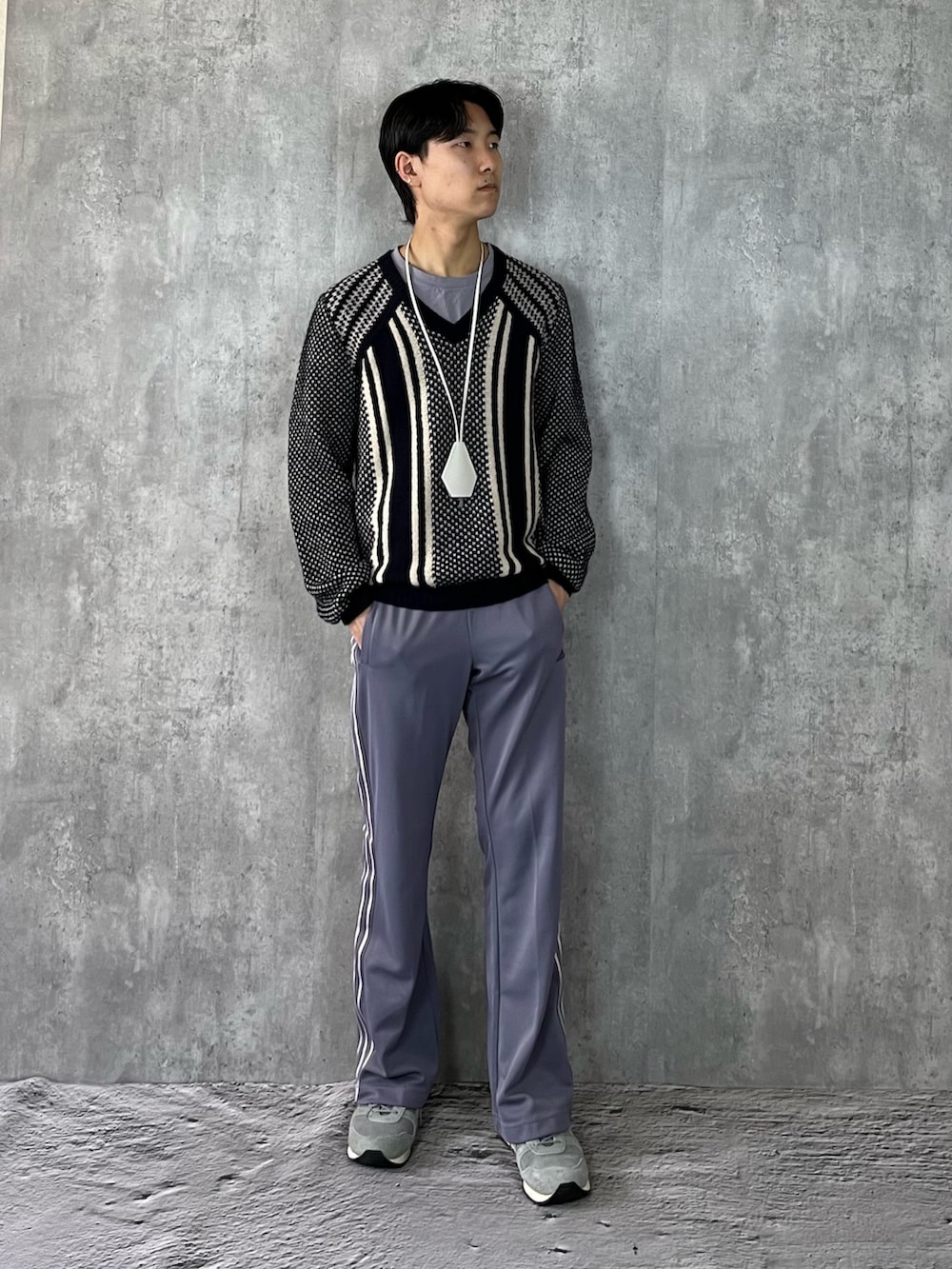 グレー系のスニーカー、パープル系のパンツ、ブラック系のニット/セーターを着用したメンズの冬コーディネートの2枚目の写真