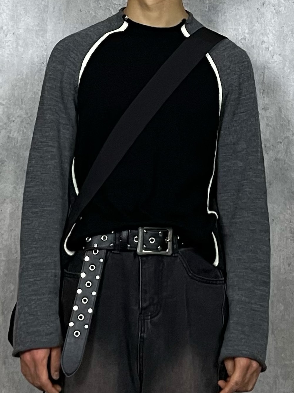 ブラック系のデニムパンツ、ブラック系のブーツ、ブラック系のショルダーバッグを着用したメンズの春コーディネートの2枚目の写真