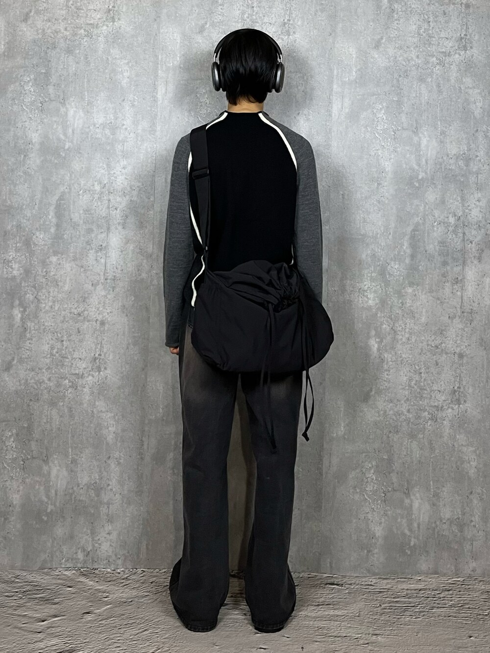 ブラック系のデニムパンツ、ブラック系のブーツ、ブラック系のショルダーバッグを着用したメンズの春コーディネートの5枚目の写真