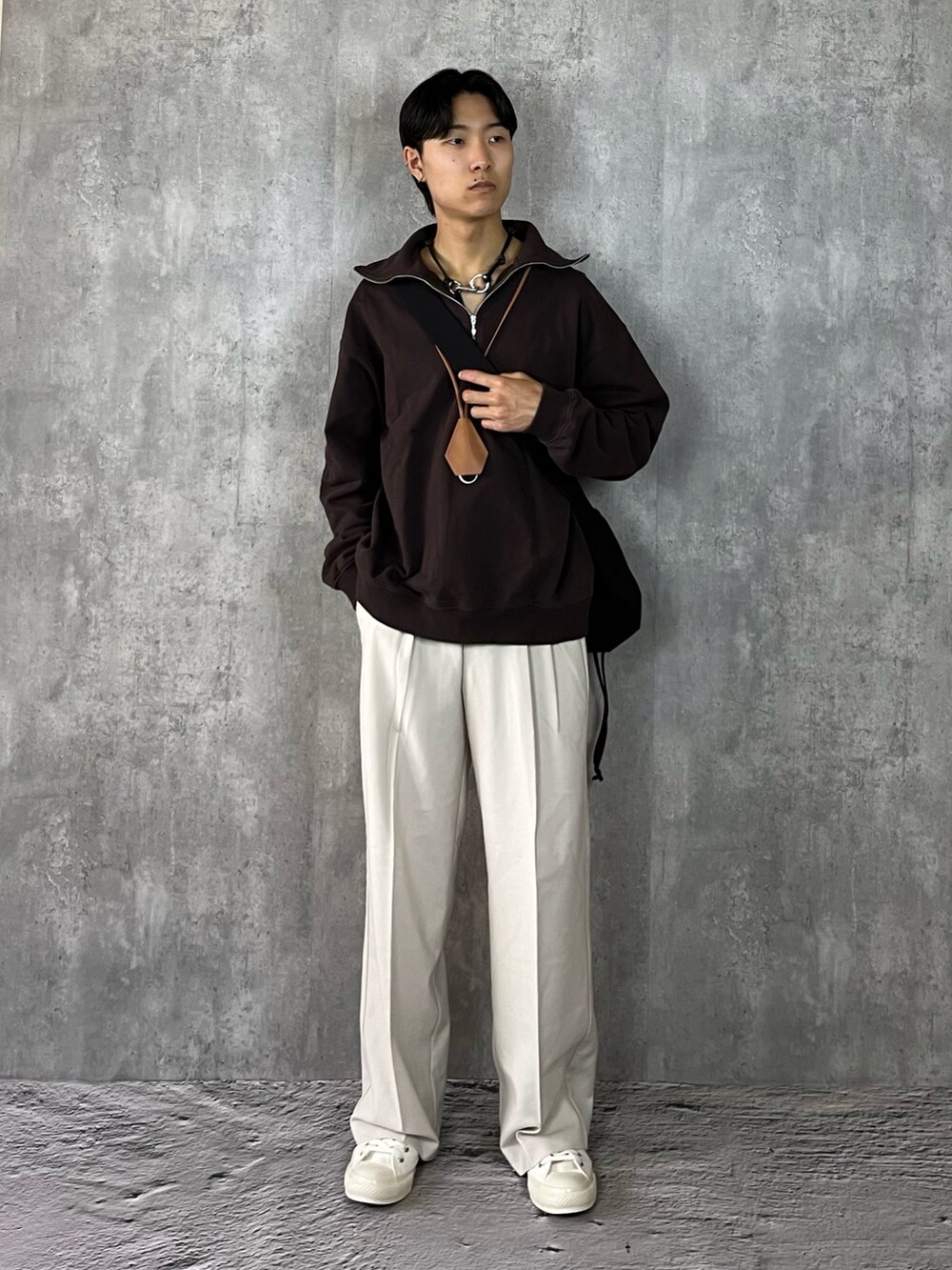 ホワイト系のスニーカー、ホワイト系のスラックス、ブラック系のブルゾンを着用したメンズの冬コーディネートの2枚目の写真