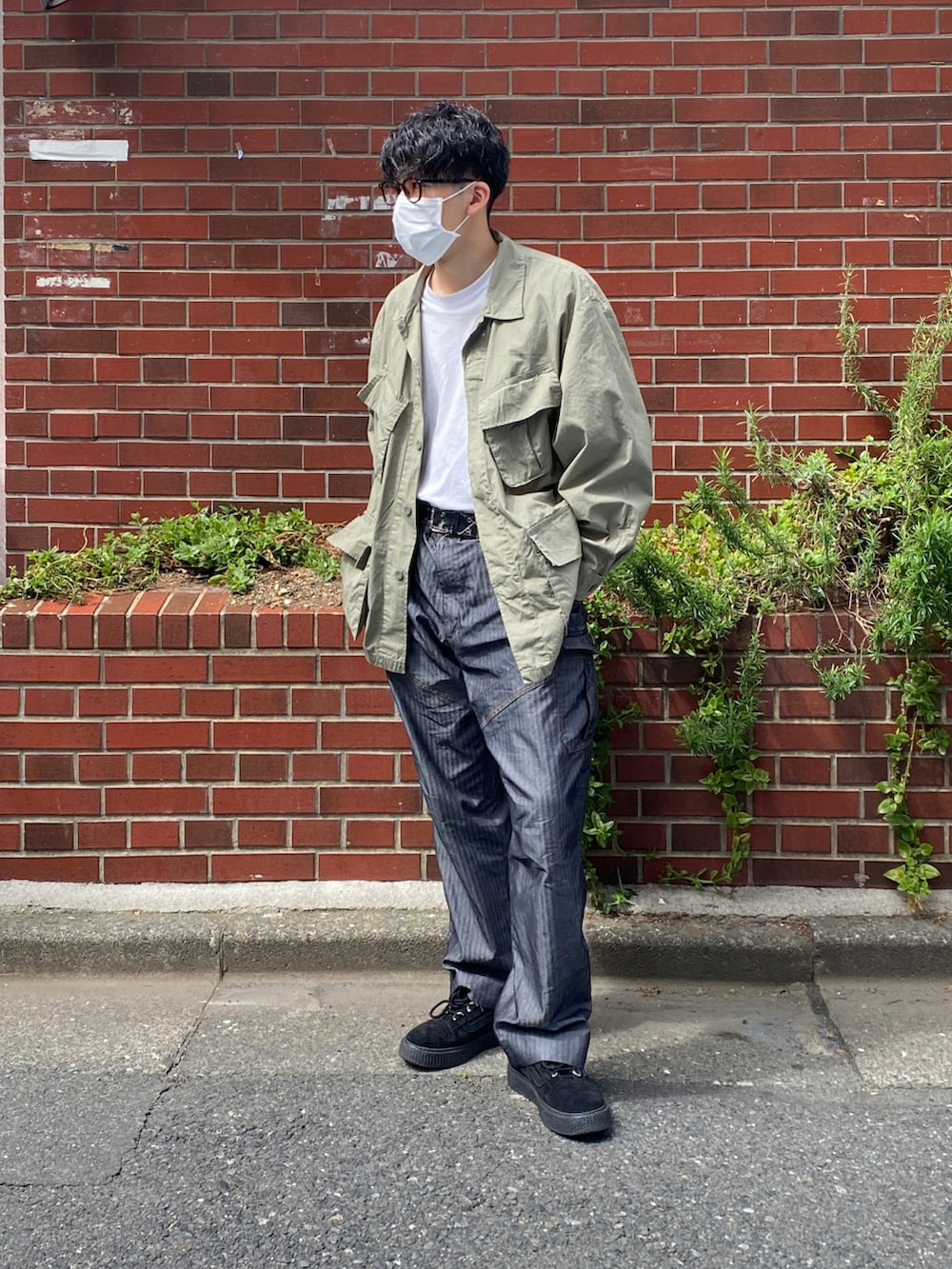 グリーン系のジャケット/アウター、ブラック系のシューズ、ホワイト系のTシャツ/カットソーを着用したメンズの春コーディネートの2枚目の写真