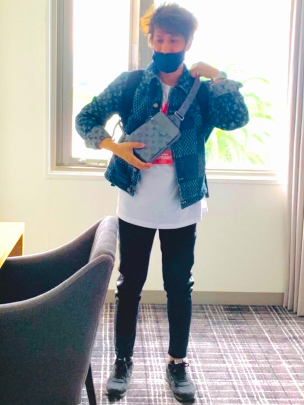 ブルー系のデニムジャケット、シルバー系のボディバッグ/ウエストポーチ、ホワイト系のTシャツ/カットソーを着用したメンズの春コーディネートの2枚目の写真