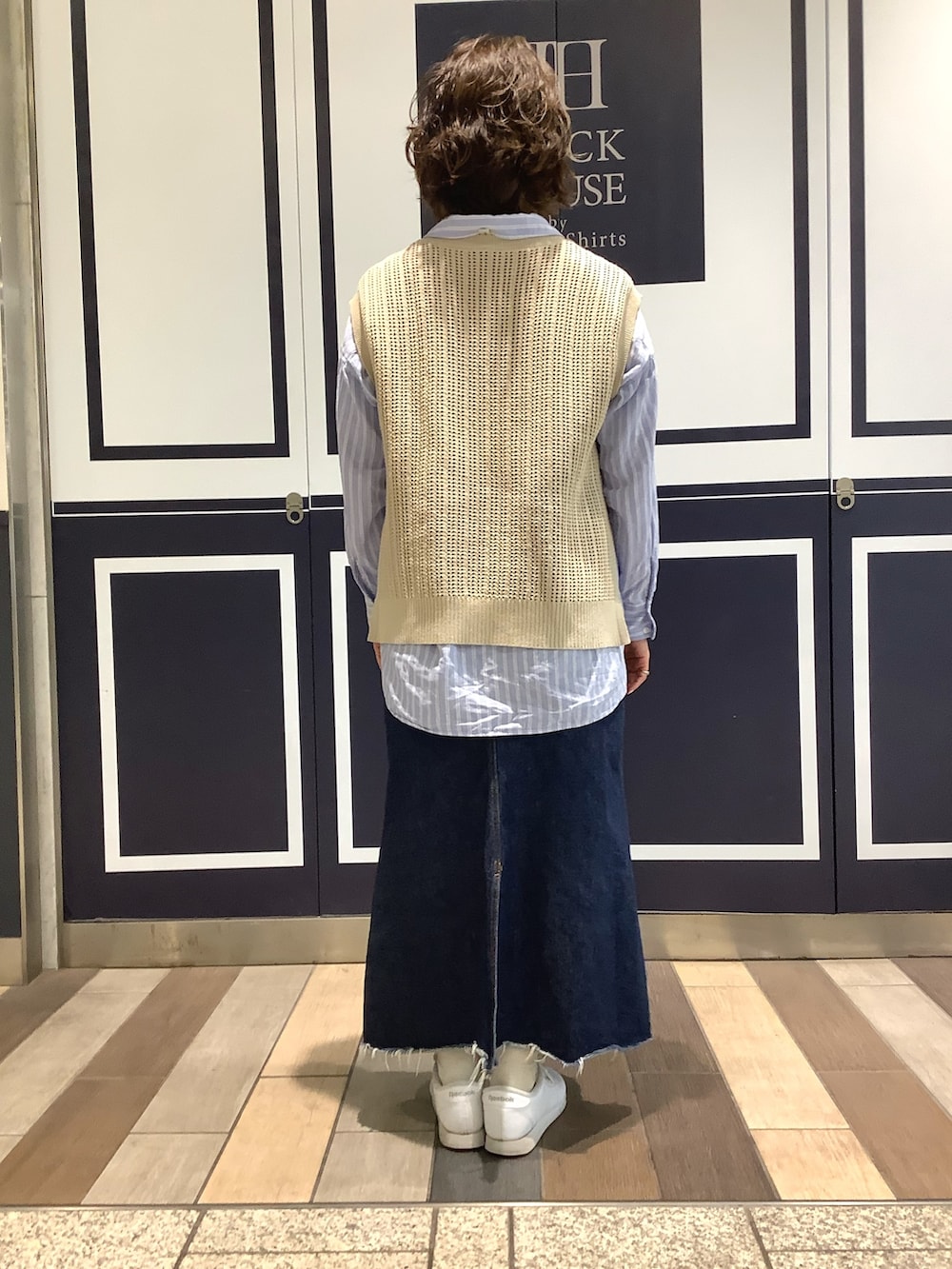 ベージュ系のベスト、ブルー系のシャツ/ブラウスを着用したレディースの春コーディネートの2枚目の写真