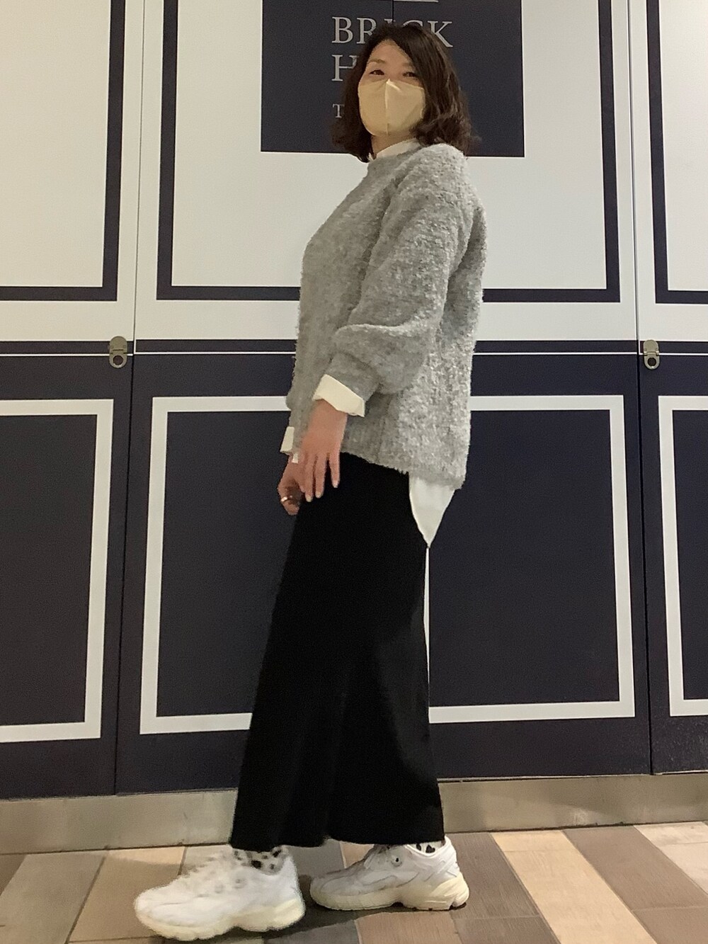 ホワイト系のシャツ/ブラウス、グレー系のニット/セーターを着用したレディースの冬コーディネートの3枚目の写真