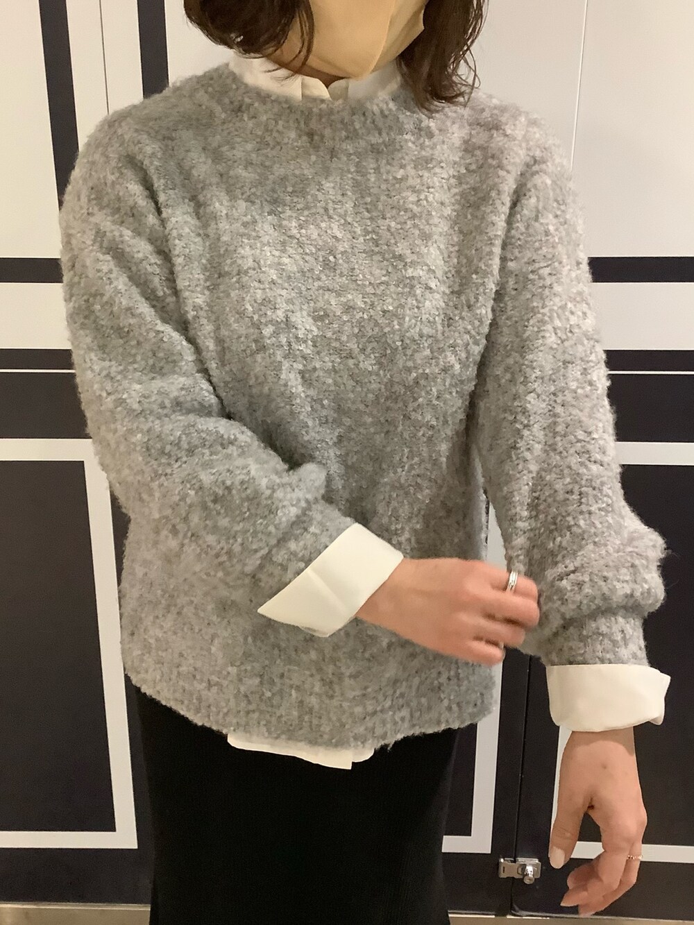 ホワイト系のシャツ/ブラウス、グレー系のニット/セーターを着用したレディースの冬コーディネートの2枚目の写真