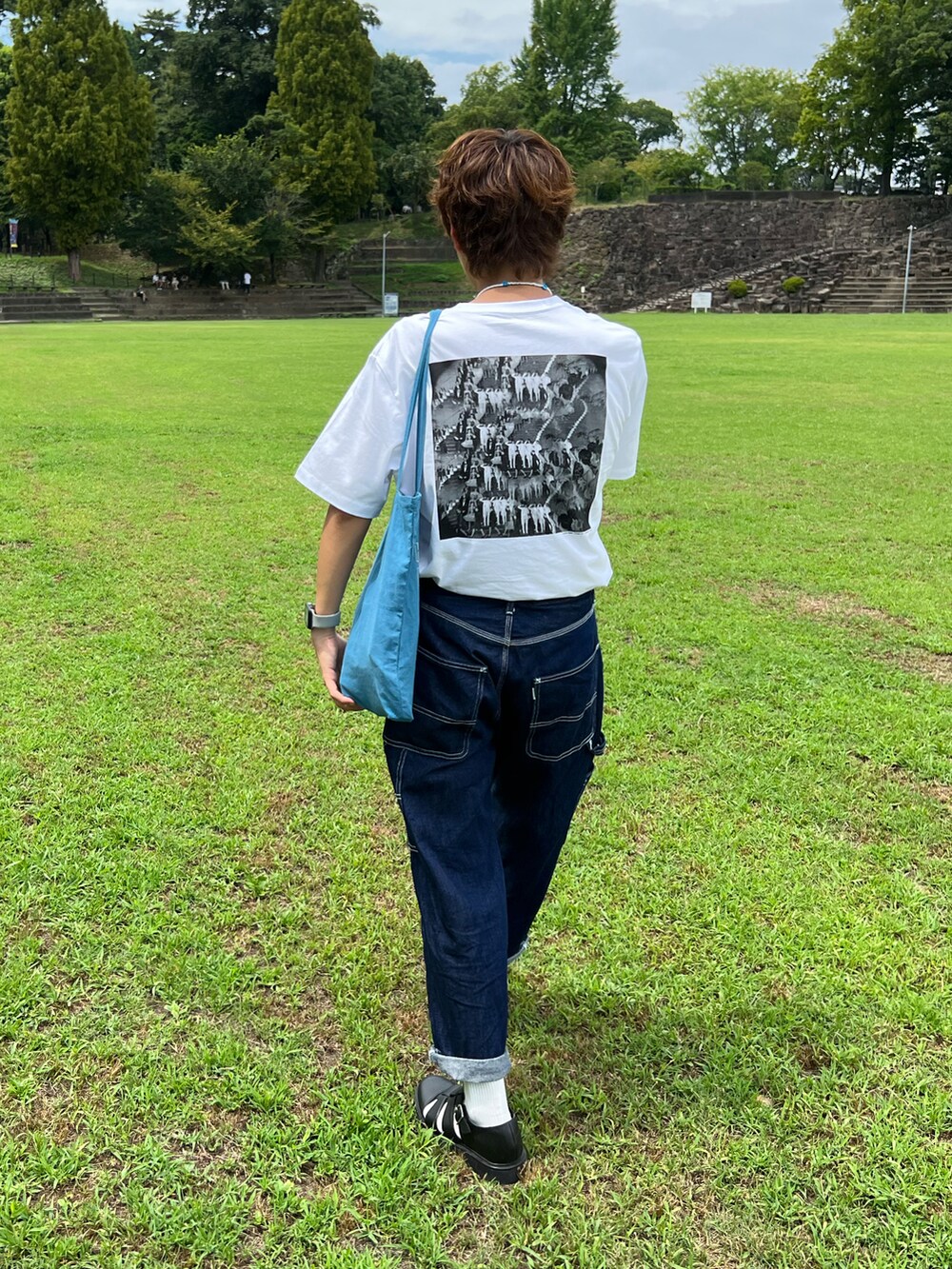 ホワイト系のTシャツ/カットソー、ブルー系のデニムパンツ、ブルー系のトートバッグを着用したメンズの夏コーディネートの2枚目の写真