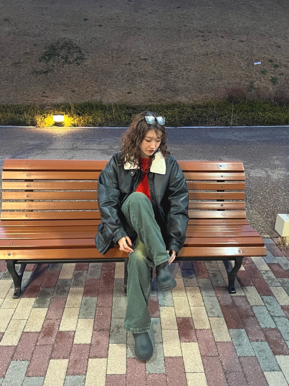 オレンジ系のニット/セーターを着用したレディースの冬コーディネートの2枚目の写真