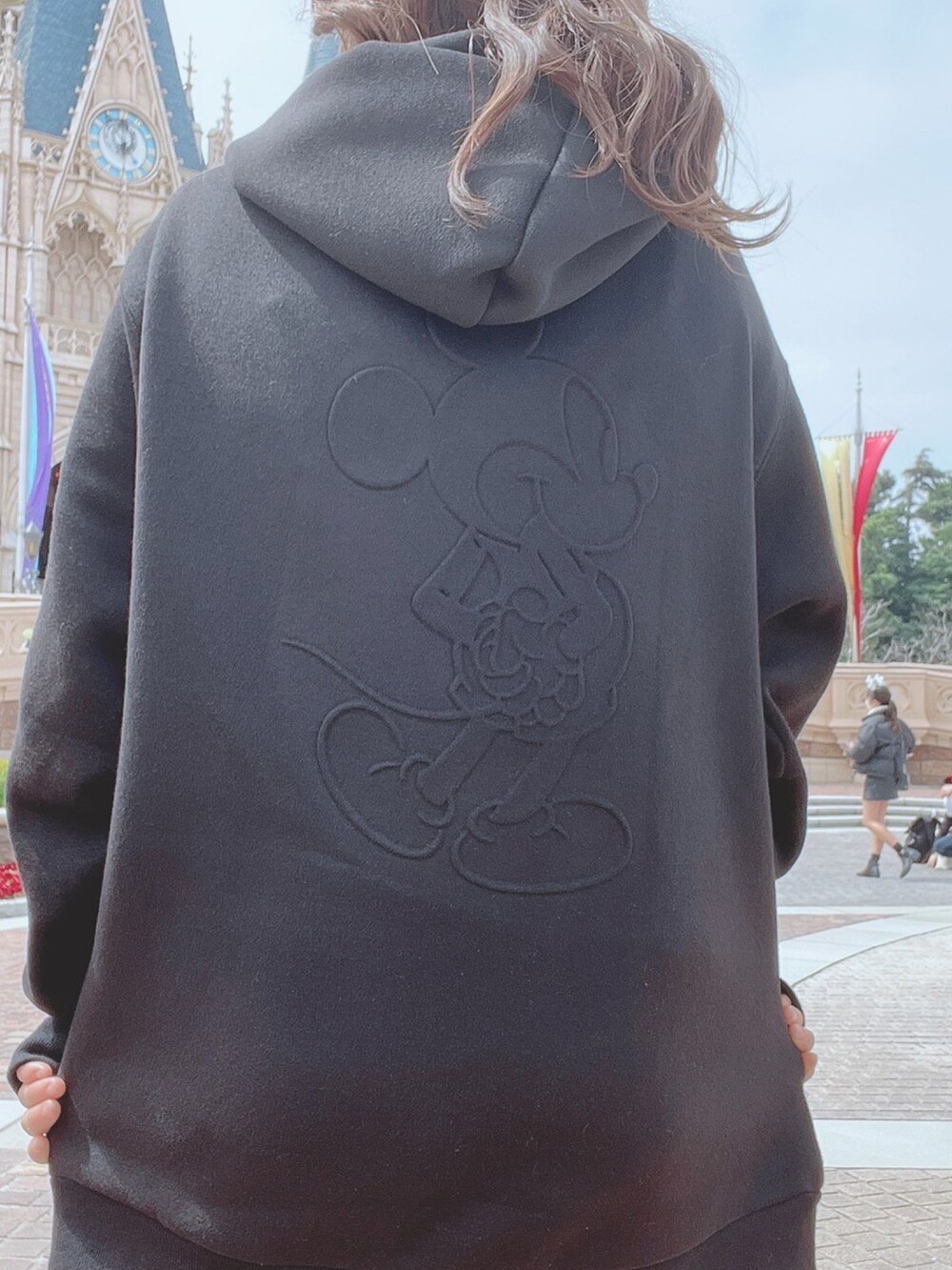 ブラック系のパーカー、ホワイト系のブーツを着用したレディースの春コーディネートの3枚目の写真