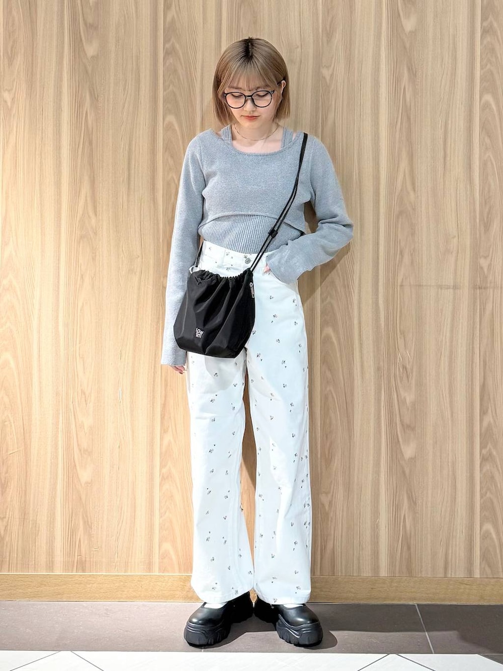 ブラック系のスニーカー、ブラック系のハンドバッグ、ホワイト系のデニムパンツを着用したレディースの春コーディネートの4枚目の写真